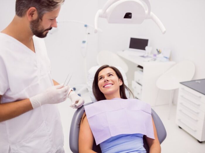 dentist-with-smiling-female-patient_107420-65277